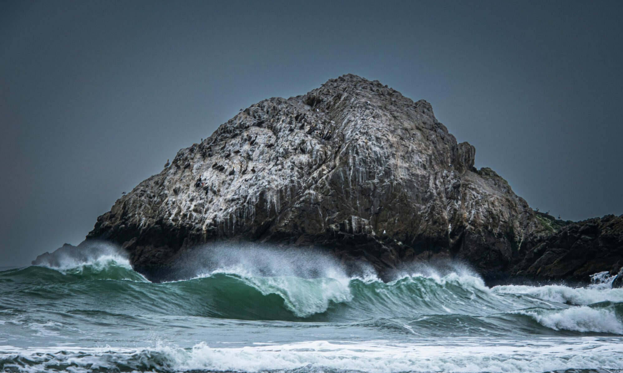 Image of San Francisco's Seal Rock towering over rough seas